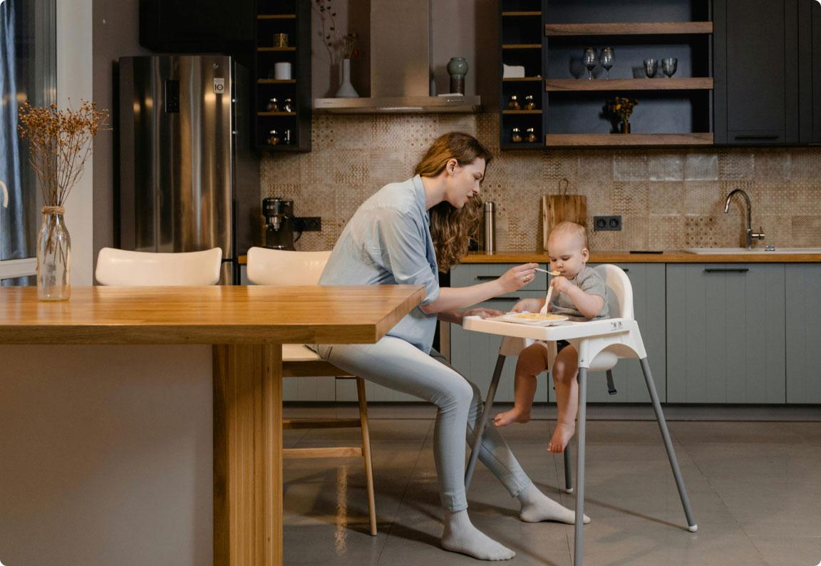 woman feeding her baby in the kitchen