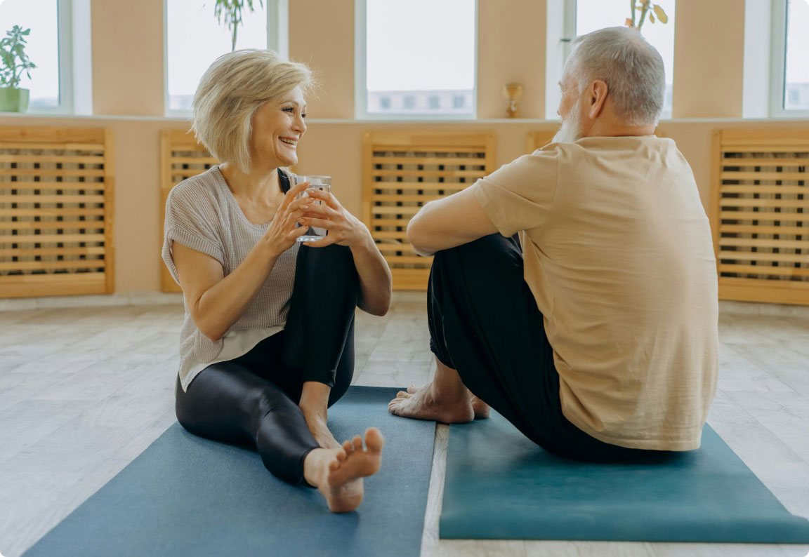 healthy senior couple stretching on yoga mats